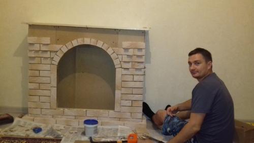 Муж с юным помощником мастерят в квартиру декоративный камин. 03