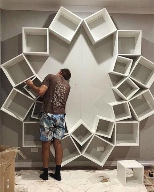 Нестандартный способ креативного хранения книг, просто достаточно собрать множество квадратных ящиков и прикрепить их к стене необычным узором.