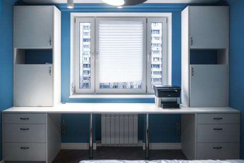 Рабочий стол в детской комнате с местами для хранения вещей и учебников.